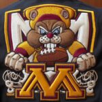 Detailed Custom Embroidery With The University Of MN Logo And Goldie The Gopher Biting A Football